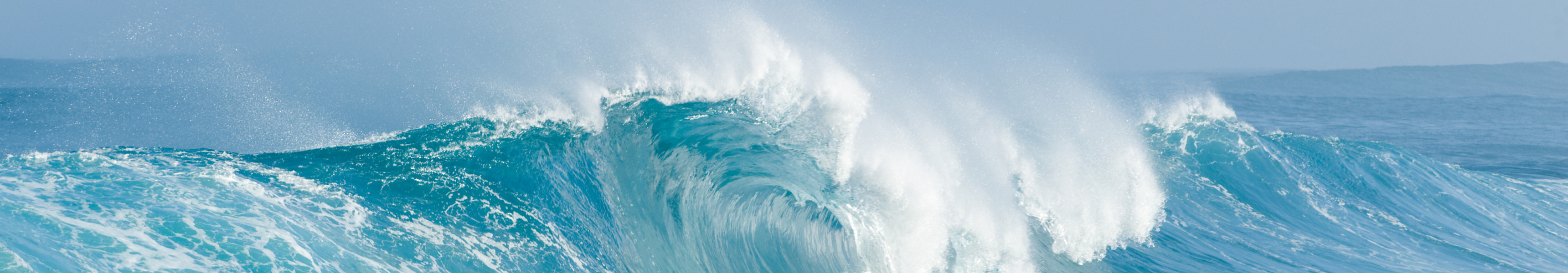 Gro&szlig;e Welle bricht im eisblauen Meer