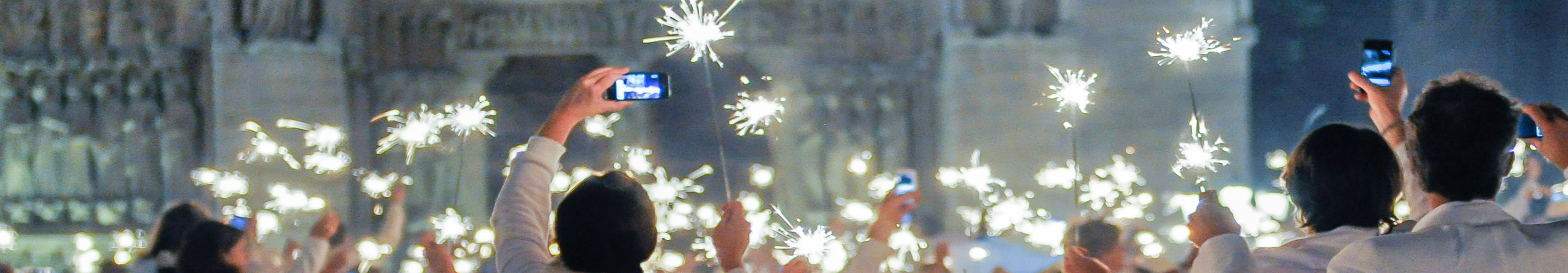 Sternenwerfer und Menschen in weißen Klamotten feiern Dîner en Blanc