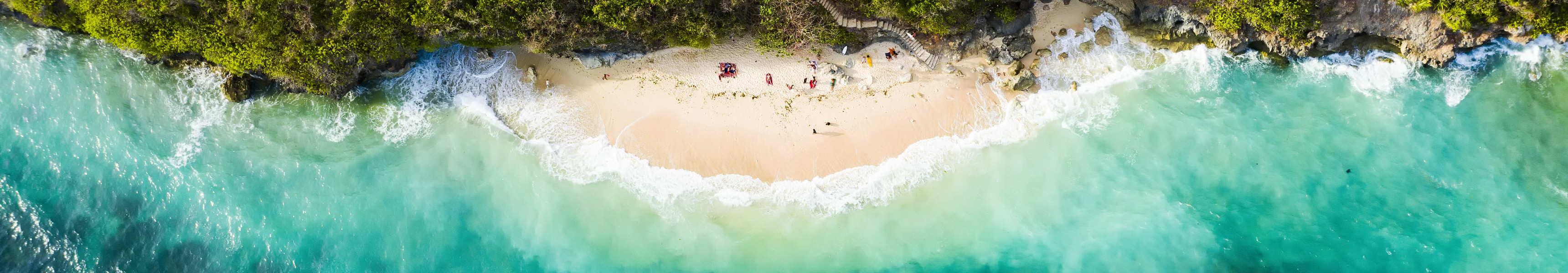 Atemberaubende Luftaufnahme einiger Touristen, die am wundersch&ouml;nen Green Bowl Beach im S&uuml;den von Bali, Indonesien, sonnenbaden.