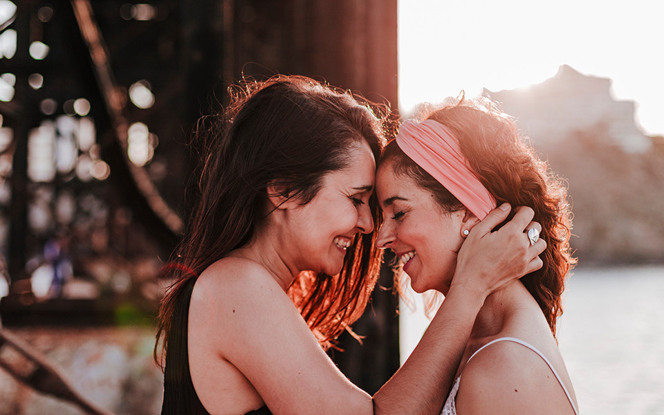 Zwei gl&uuml;ckliche Frauen lachen sich an in Sitges