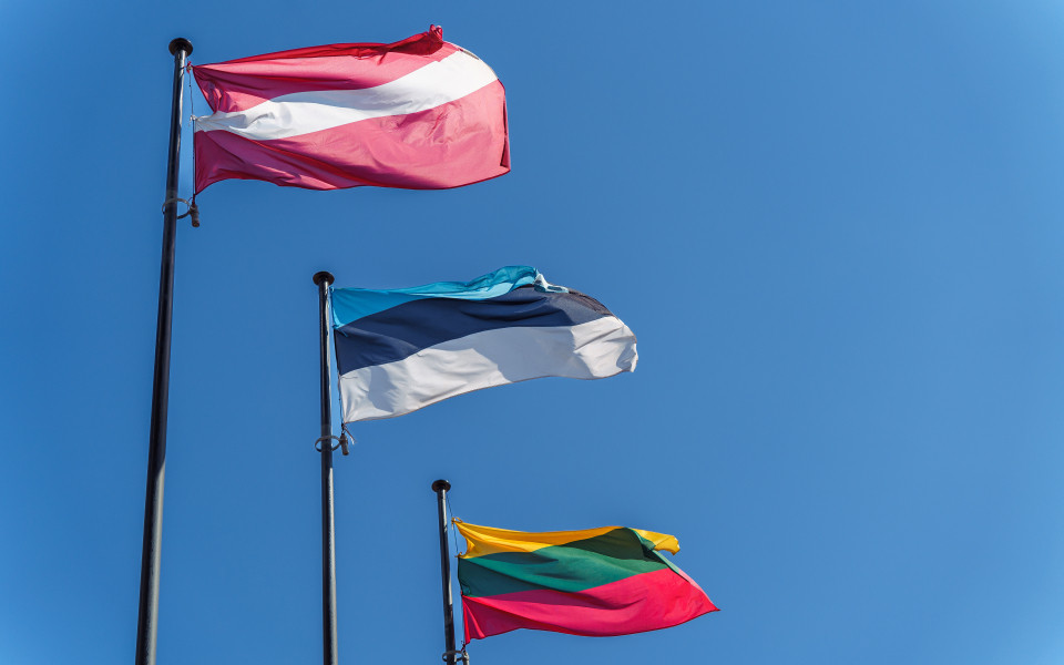 Die Flaggen der drei baltischen L&auml;nder Litauen, Lettland und Estland flattern vor einem strahlend blauen Himmel