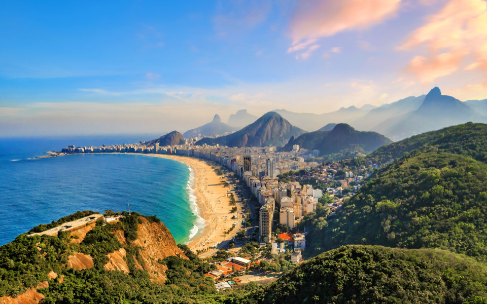 Stadtpanorama von Rio de Janeiro mit Copacabana-Strand, Hochhäusern und umliegenden Hügeln.